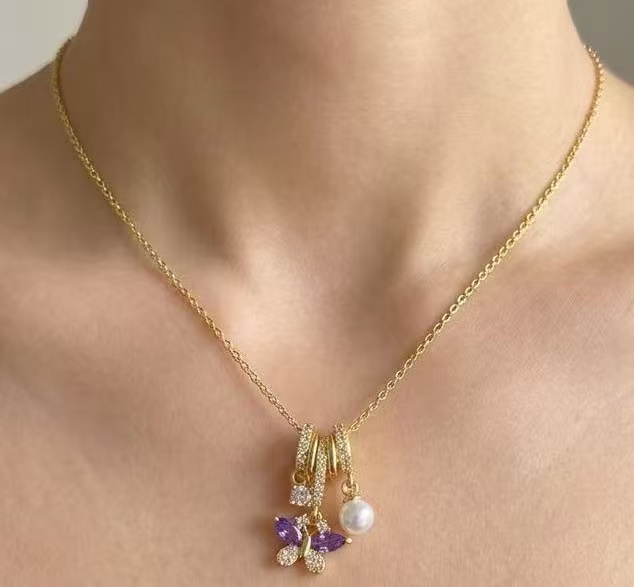 模特佩戴金色链条与紫色蝴蝶吊坠的真实素材图